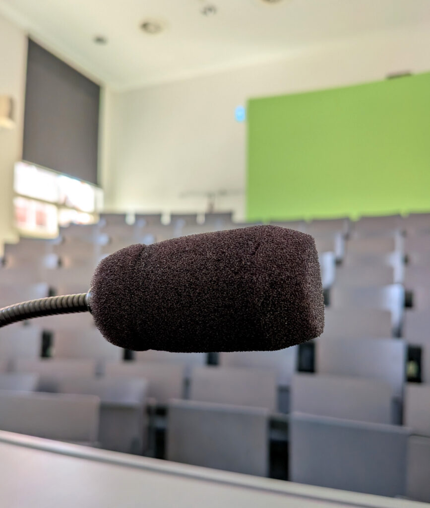 Vorlesungssaal vom Pult ausgesehen, Fokus auf Mikrofon Vorlesungssaal vom Pult ausgesehen, Fokus auf Mikrofon